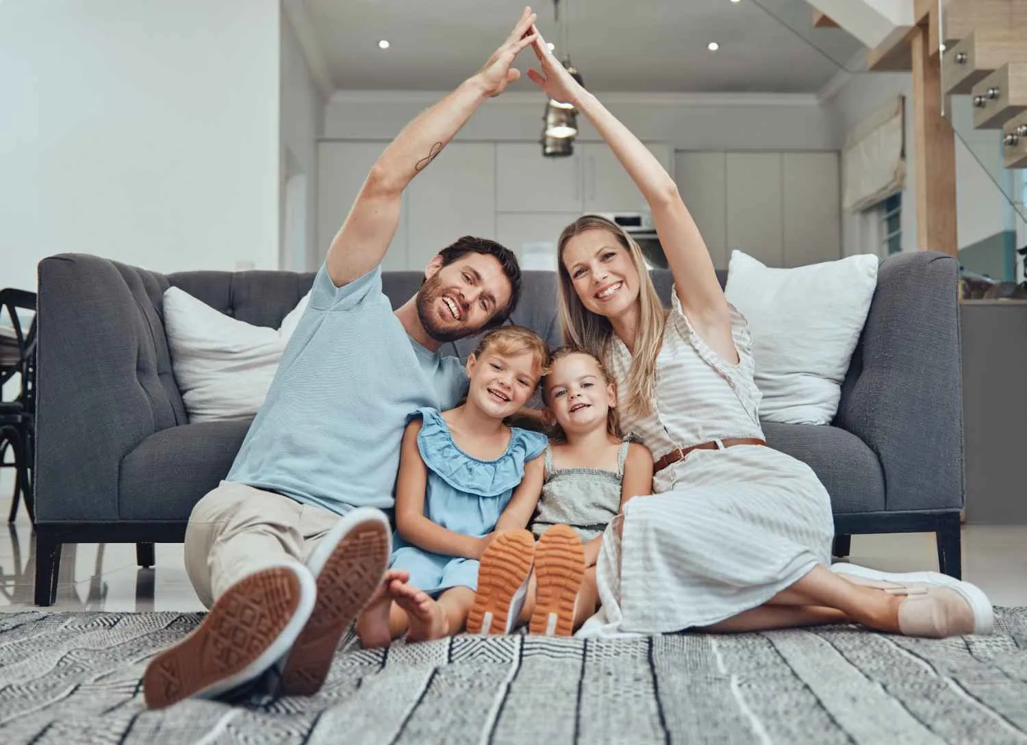 Family making a roof shape with their hands at home